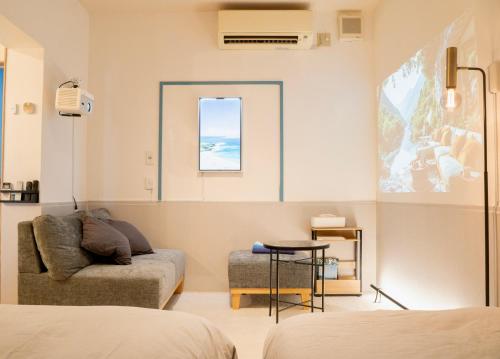 a living room with a couch and a window at Blue Nest Takamatsu in Takamatsu