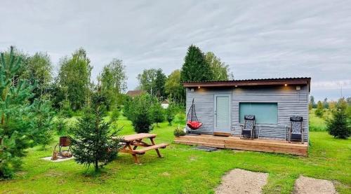 Cabaña pequeña con mesa de picnic en un patio en Välja Puhkemaja, en Üksnurme