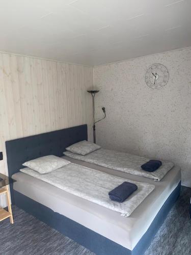 a bedroom with two beds and a clock on the wall at Välja Puhkemaja in Üksnurme