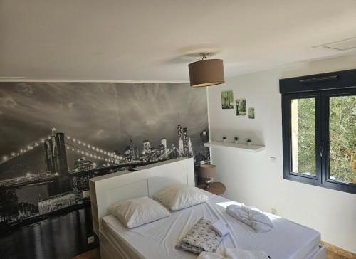 une chambre avec un lit et un tableau au mur dans l'établissement Les oliviers, à Saint-Didier