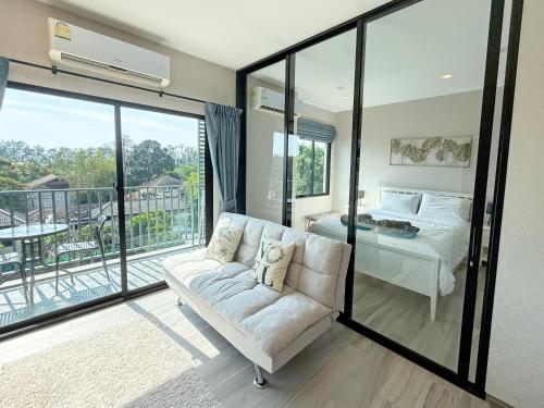 a living room with a couch and a bed at The Title Residencies Naiyang by Mill in Nai Yang Beach