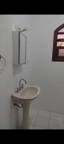 a white bathroom with a sink and a mirror at Hotel Moinho de Pedra in Serra Negra
