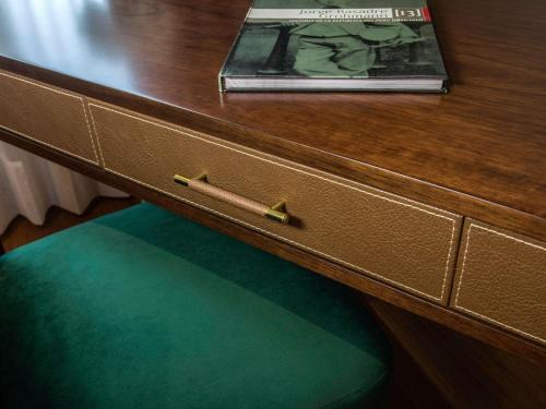 a wooden drawer with a book on top of a desk at Manto Hotel Lima - MGallery Collection in Lima