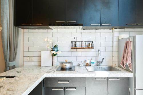 a kitchen with a sink and a refrigerator at duplex 1 bedroom apartment on Wuyuan Road close Changshu Road station in Shanghai