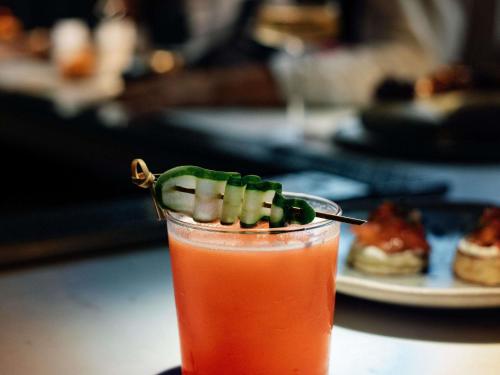 a drink with a pickle spear on top of it at Manto Hotel Lima - MGallery Collection in Lima