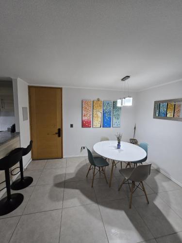 a dining room with a white table and chairs at Dpto Vista al Mar, La Herradura in Coquimbo