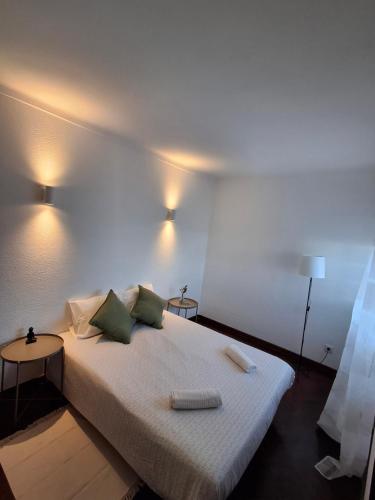 a bedroom with a bed with two pillows on it at Casa R in Sesimbra