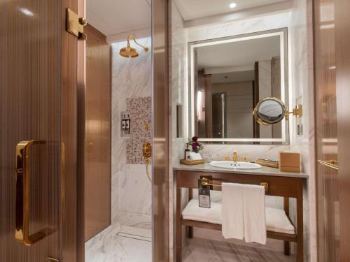 a bathroom with a sink and a mirror at Admiral Hotel Manila - MGallery Collection in Manila