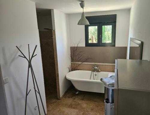 une salle de bain avec une baignoire et un lavabo dans l'établissement Les oliviers, à Saint-Didier