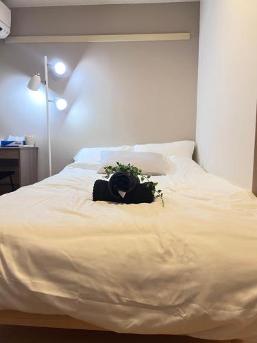 a white bed with a bouquet of flowers on it at Nishi Kawaguchi Buryry in Kawaguchi