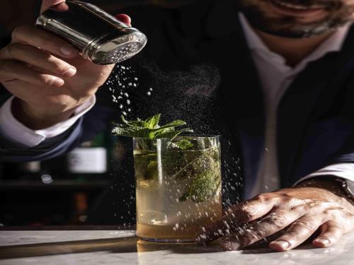 a man is sprinkling a drink in a glass at Habita79 Hotel Pompeii - MGallery Collection in Pompei