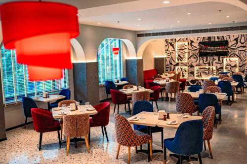 ブバネーシュワルにあるWelina Hotelの窓のあるレストラン(テーブル、椅子付)