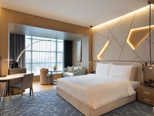 a hotel room with a bed and a desk at La Cigale Hotel Managed by Accor in Doha