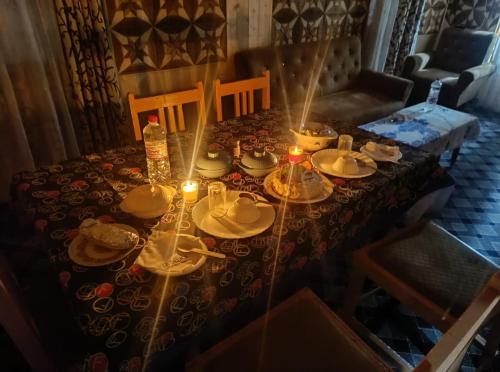 a table with plates and hats and candles on it at Little blue Moon in Srinagar
