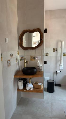 a bathroom with a black sink and a mirror at Refúgio da Quinta Nere Maitia in Santarém
