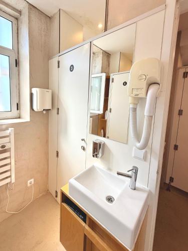 a bathroom with a sink and a mirror at Rivoli Cinema Hostel in Porto