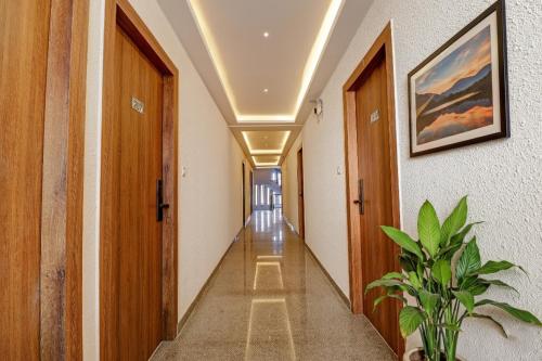 a corridor of a hallway with wooden doors and a plant at FabHotel Rotano Grand - Nr Marathahalli Bridge in Bengaluru