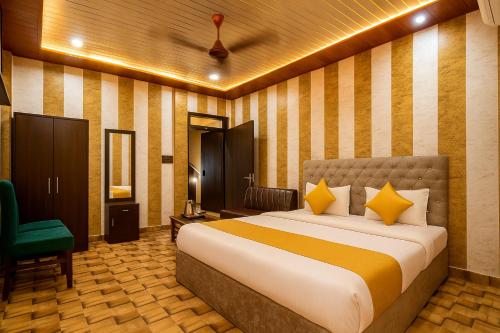a bedroom with a bed and a green chair at Comfort Stay - Saheed Path Ahimamau, Near Lulu Mall in Lucknow