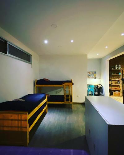 a bedroom with two bunk beds and a desk at Casa Los Nogales in Roldán