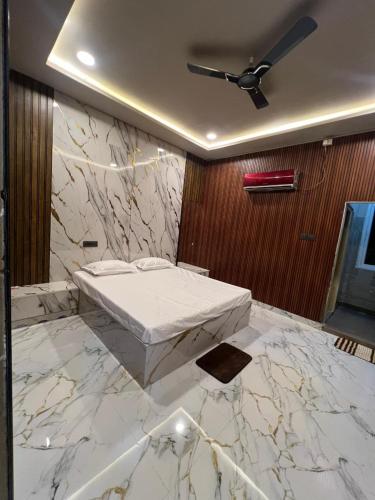 a bedroom with a bed and a marble wall at N R GUEST ROOMs in Warangal