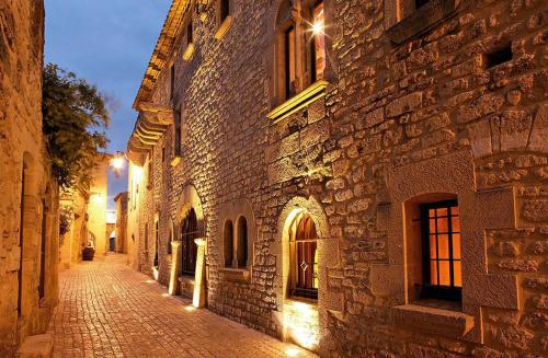une rue pavée dans un vieux bâtiment la nuit dans l'établissement Le Mistral - Pont du Gard - Cozy & Intime - WiFi fibre -TV, à Saint-Bonnet-du-Gard