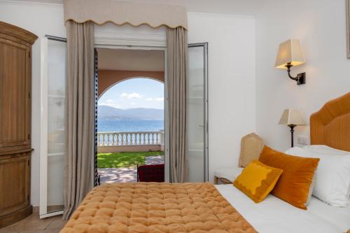 a bedroom with a bed and a view of the ocean at Hôtel Les Mouettes - Teritoria in Ajaccio