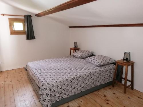 ein Schlafzimmer mit einem Bett und zwei Kissen darauf in der Unterkunft Maison de 80m2 avec cour fermée et sécurisée in Crozes-Hermitage