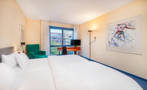 a hotel room with a white bed and a window at Radisson Blu Fürst Leopold Hotel in Dessau