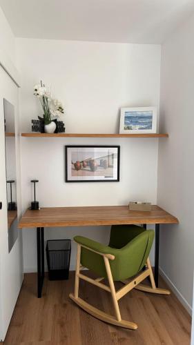 a green chair sitting under a wooden desk at Refúgio da Quinta Nere Maitia in Santarém