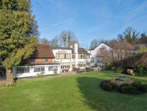 a large white building with a lawn in front of it at Dancenter Boutique Luxury Gatwick Airport in Dorking