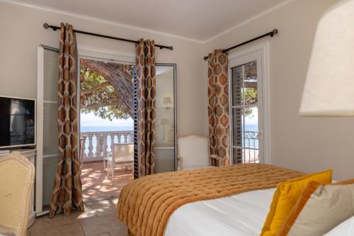 a bedroom with a bed and a balcony at Hôtel Les Mouettes - Teritoria in Ajaccio