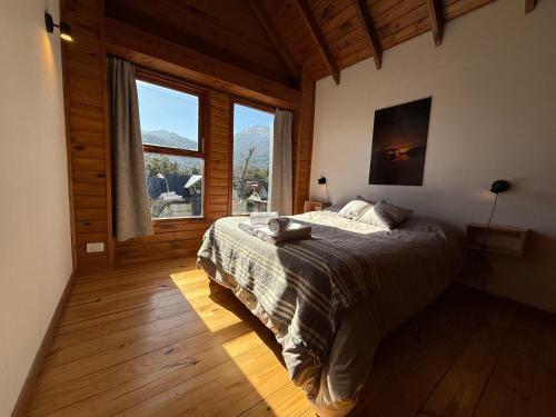 a bedroom with a bed and a large window at Sombra Verde - Alojamiento Turistico in Villa La Angostura
