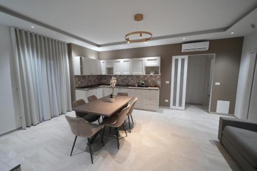 a kitchen and dining room with a wooden table and chairs at Mariluna Luxury Apartments in Falconara Albanese