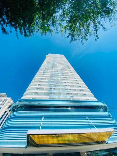 a tall white building with a blue sky in the background at TMS Quy Nhơn - Hupa Apartment View Biển in Quy Nhon
