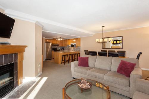 a living room with a couch and a table at Woodrun Lodge 302 | Large Condo w/ Shared Heated Pool & Large Hot Tub in Whistler
