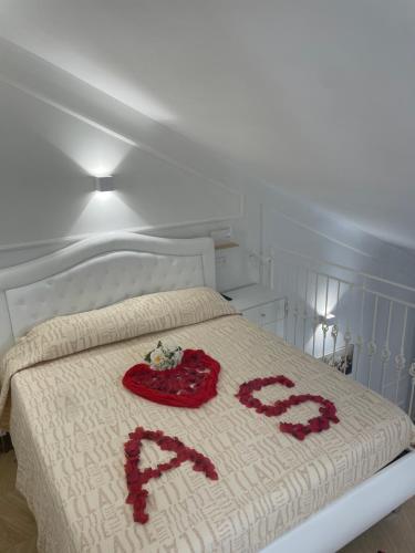 a bed with two red ribbons on it at Camilla Luxury Home in Nemi