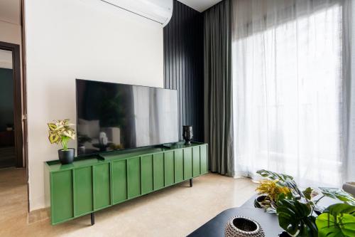 a living room with a flat screen tv on a green cabinet at Habitat Towers in Sheikh Zayed