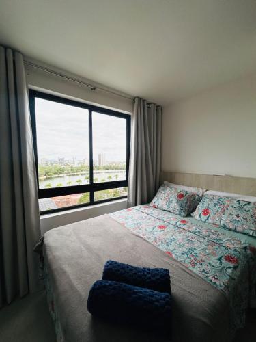 a bedroom with a bed and a large window at Flat de alto padrão no centro da cidade in Campina Grande