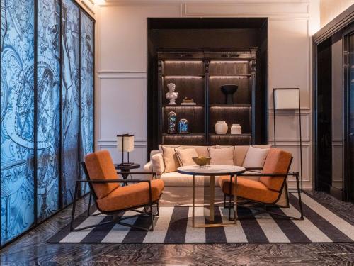 a living room with a couch and a table and chairs at Sofitel Adelaide in Adelaide