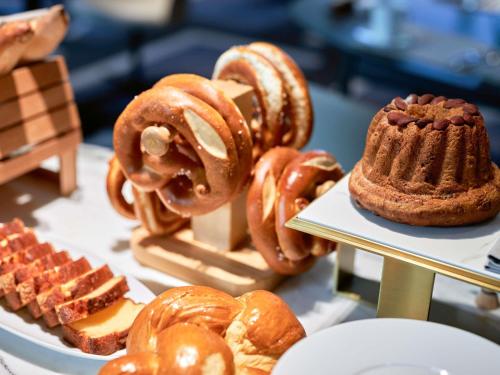 a display of different types of pastries on a table at L'Esquisse Hotel & Spa Colmar - MGallery Collection in Colmar