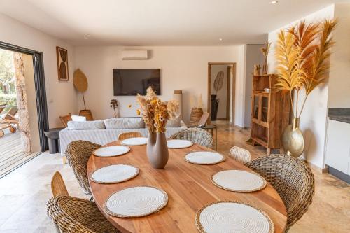 una mesa con platos y sillas en la sala de estar. en Villa Campemu Di Lecci, en Lecci