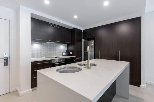 a kitchen with a white counter and a sink at Lagoon Sanctuary - Resort Living by Four Mile Beach in Craiglie