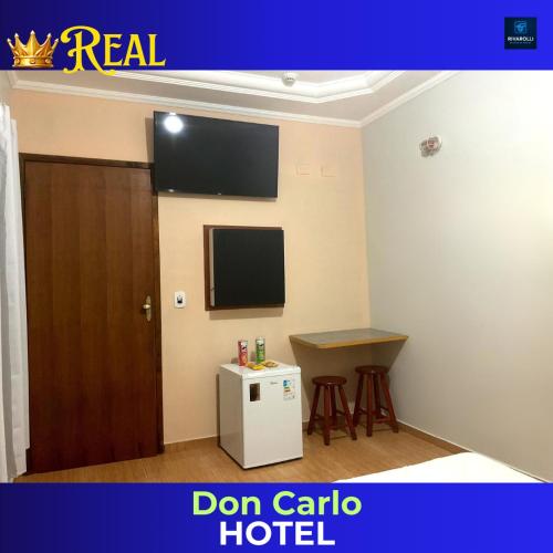 a room with a door and a tv and a table at Don Carlo Hotel in São Bernardo do Campo