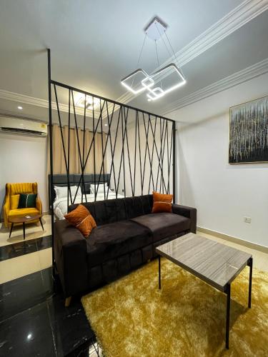 a living room with a couch and a table at Teak Gardens T1 - East Legon in Accra