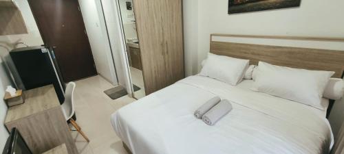 een slaapkamer met een bed met een handdoek erop bij Novara Living Springwood Residences in Warungmangga