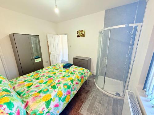 a bedroom with a bed and a glass shower at BIG double room Attached Shower near to city center in Nottingham
