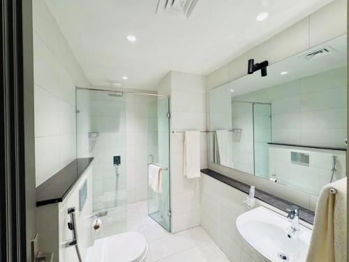 a bathroom with a sink and a glass shower at Taj Hotel Premium Residency F-7 Islamabad in Islamabad
