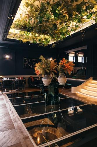 a restaurant with a glass table with plants on the ceiling at Komana Hotel Binbirdirek in Istanbul
