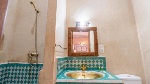 a bathroom with a sink and a mirror and a toilet at Riad Abaka hotel & boutique in Marrakech