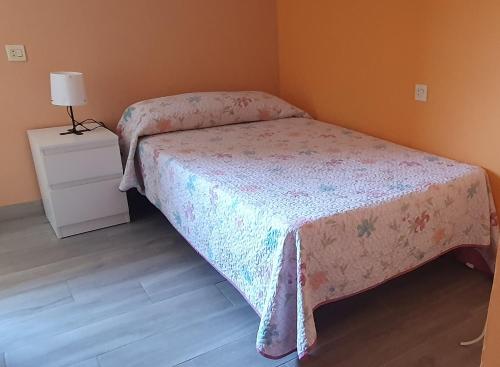 a small bedroom with a bed and a night stand at Casa Rural Nito in Villayón